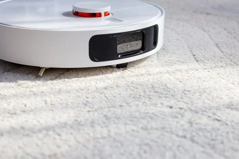 Close-up of a white smart robotic vacuum cleaner with navigation sensors on a Stock Photos