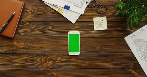 Close up of the white smartphone with a green screen lying vertically on the Stock Footage 88450606