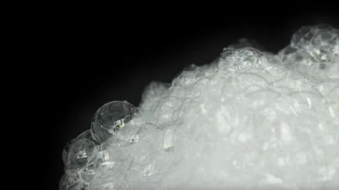 Close-Up of White Soap Foam Bubbles Popping on Black Background. Stock Footage 334932426