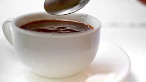 Close up of white sugar being poured into a cup of black coffee Stock Footage 279185288
