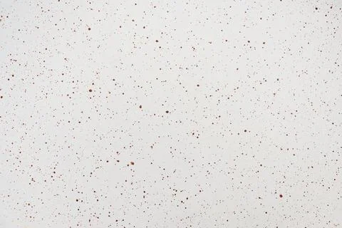 Close-up of a white surface featuring a fine pattern of reddish-brown paint.. Stock Photos
