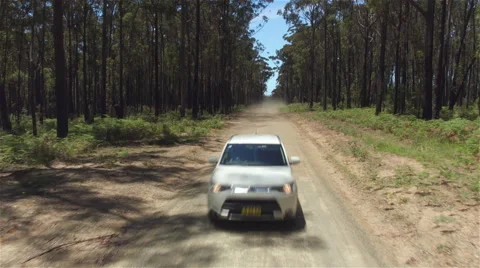 CLOSE UP: White SUV car driving fast along dry road leaving cloud of dirt behind Stock Footage