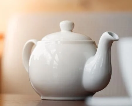 Close-up of white teapot on the table. Stock Photos