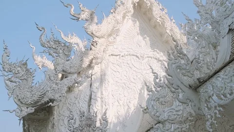 Close up of White temple rooftop with intricate carvings details under blue sky Stock Footage 315856628