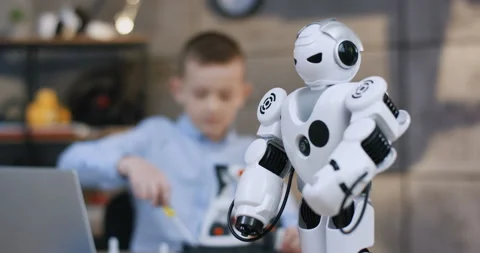 Close up of the white toy robot in front of the camera, and blurred teen small Stock Footage 135840249