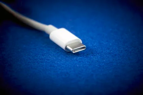 Close-Up of white USB Type-C cable on blue background. Stock Photos