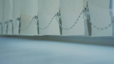 Close up of white vertical blinds with connecting chain at bottom. Soft light Stock Footage 276321347