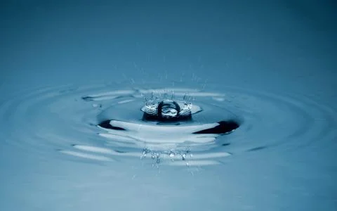 Close-up white water drop falling down. Stock Photos