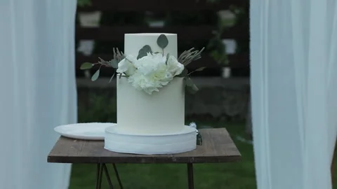 A close-up of a white wedding cake decorated with fresh white roses outdoors Stock Footage 324815000