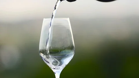 Close up of white wine being poured into a wine glass in slow motion Stock Footage 87857430