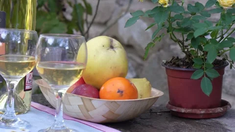 Close-up of White Wine Glasses and Autumn Fruits in a Rustic Outdoor Setting Stock Footage 323403635