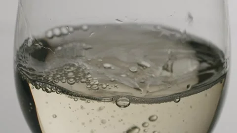 Close up of white wine pouring into a glass in slow motion Stock Footage 342736345