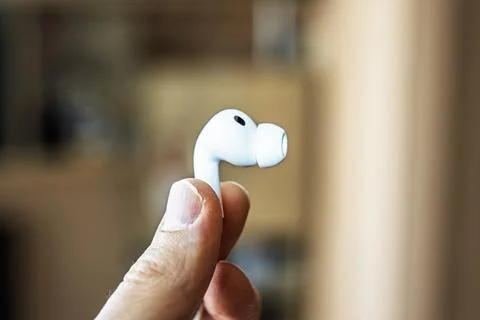Close-up of a white wireless earbud Apple aipods pro 3 held in fingers, foc.. Stock-Fotos