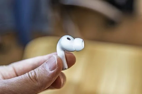 Close-up of a white wireless earbud held in fingers Apple aipods pro 3 Stock-Fotos
