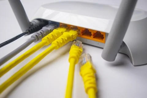 Close-up of a white wireless router back panel with multiple connected yell.. Stock Photos