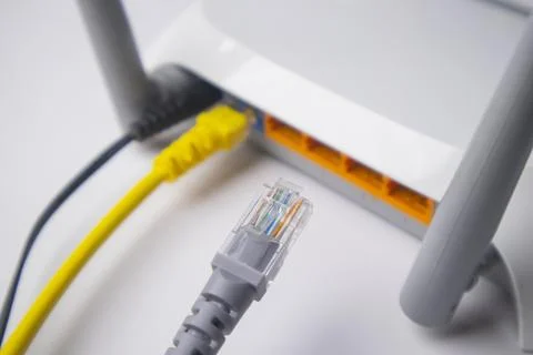 Close-up of a white wireless router back panel with one yellow Ethernet cab.. Stock Photos