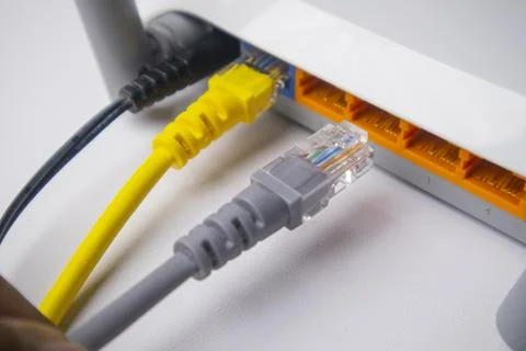 Close-up of a white wireless router back panel with one yellow Ethernet cab.. Stock Photos