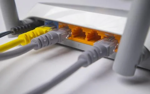 Close-up of a white wireless router back panel with multiple Ethernet cable.. Stock Photos