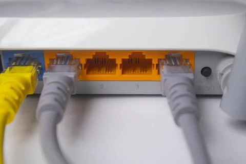 Close-up of a white wireless router back panel with one yellow Ethernet cab.. Stock Photos