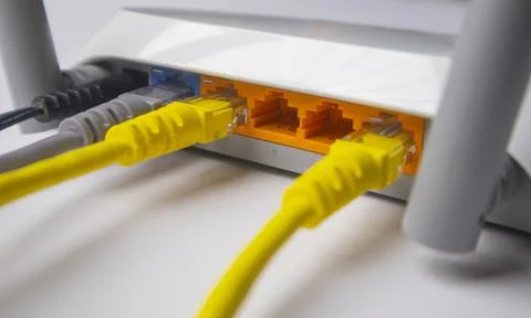 Close-up of a white wireless router back panel with multiple Ethernet cable.. Stock Photos
