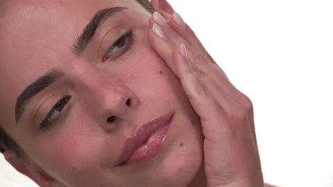 Close up of a white woman's face applying essential oil to her skin. Isolated on Stock Footage 197440479