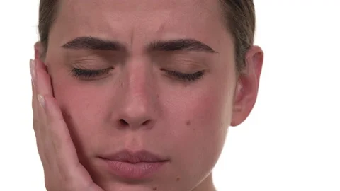 Close up of white woman's face as she touches the side of her face in pain. Stock Footage 197440104