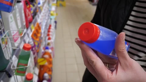 Close-up of white young womans hands holding a jar of blue liquid for cleaning a Vídeo Stock 314033696