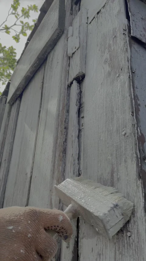 Close-up whitewashing barn wall with brush Stock Footage 334330371