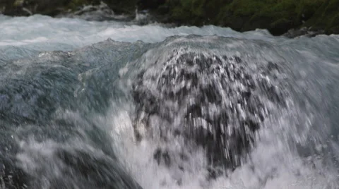 Close-up whitewater streaming over a boulder Stock Footage 59528512
