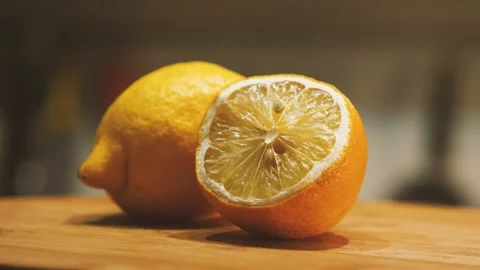 Close-up of whole and cut in half lemons lying on a kitchen board 스톡 동영상 160431069
