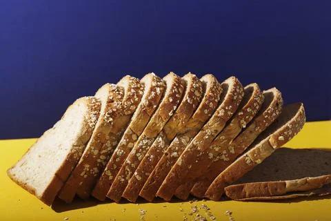 CLose Up Whole Grain Bread with Oat Flakes and Seeds on Blue and Yellow Stock Photos