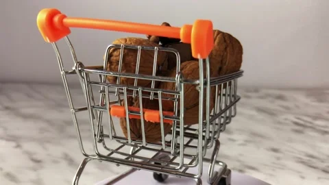 Close-up. whole walnuts lie in a small shopping cart Video stock 234998675