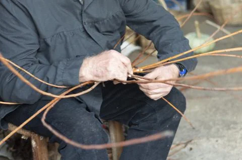 Close-up of a wicker craftsman's hands preparing a basket Stock Photos