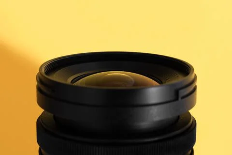 Close-up of an wide angle camera lens with glass reflections on yellow Stockfoto's