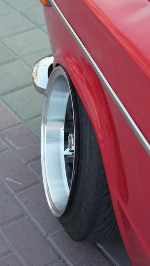 Close-up of wide custom rim on stretched tire of red vintage car. Stock Footage 341134966