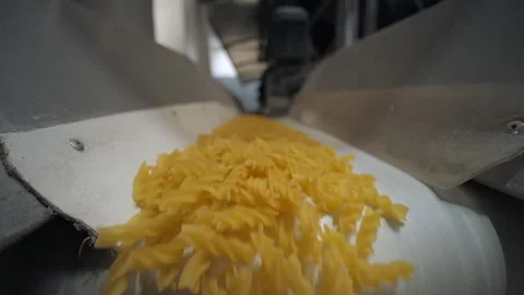 Close wide shot raw pasta macaroni running white conveyor belt on pasta factory. Stock Footage 162500758
