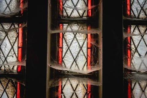 Close up from a widow with spiderwebs, in an old abandoned church. Stock Photos