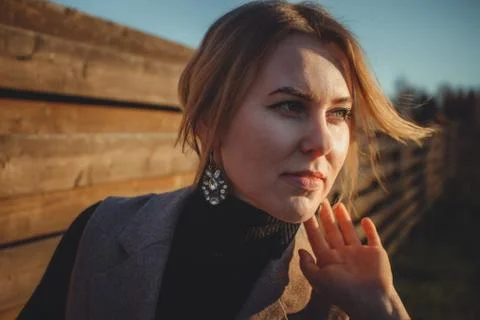 Close up. Wind develops hair stylish girl with beautiful jewelry. Portrait of a Stockfoto's