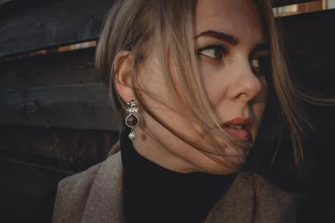 Close up. Wind develops hair stylish girl with beautiful jewelry. Portrait of a Foto stock