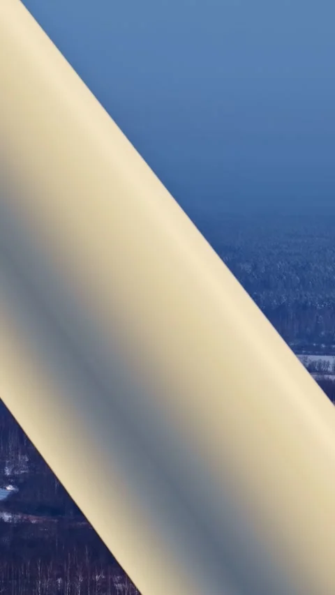 Close-Up of Wind Turbine Blade Over Snowy Forest Landscape Stock Footage 336101771
