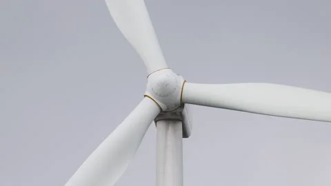 Close-Up of Wind Turbine Hub with Rotating Blades Against Grey Sky Stock Footage 333627119