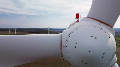 Close-up of a wind turbine with a red warning light, showing several turbines in Stock Footage 289143328