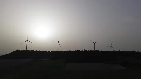 Close-up wind turbines rotating in hazy sunset sky – renewable energy Stock Footage 331284258