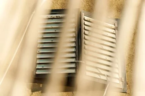 Close window behind a rusty fence. Grunge architecture design Stock Photos