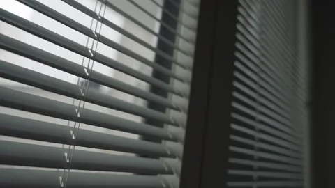 Close up on window blinds or shades being opened letting light inside room Vidéo 257792657