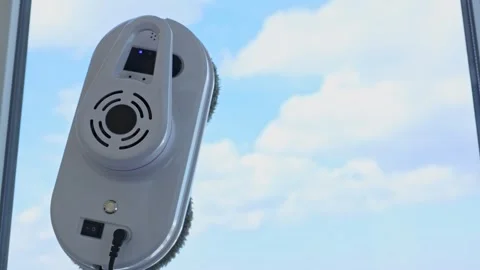 A close-up of a window cleaner robot moving across the glass moving rotating Stock Footage 307167857