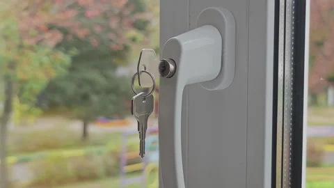 Close up of a window handle with a childproof lock and a key. Home safety Stock Footage 346536189