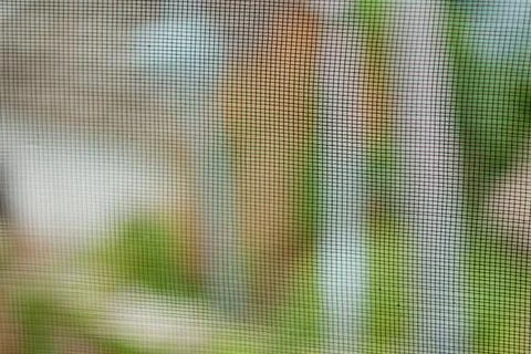 Close up of a window screen mesh, forming a protective grid texture 스톡 사진