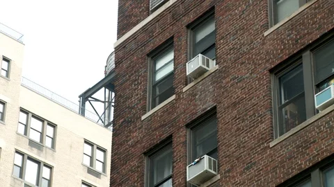 Close up of windows with air conditioning units in apartment building, day. 스톡 동영상 110758651