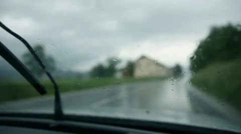 Close up on windshield while rain drops falling and wipers cleaning Video stock 28976652